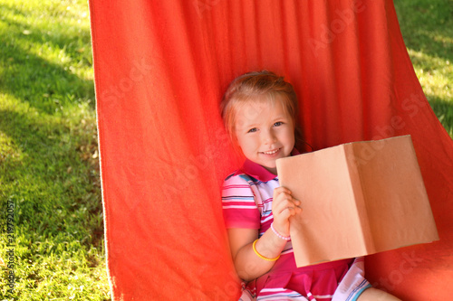 Cute little girl reading bo...