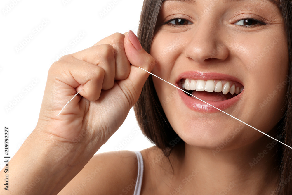 Young woman flossing her teeth on white background Young woman flossing her teeth on white background