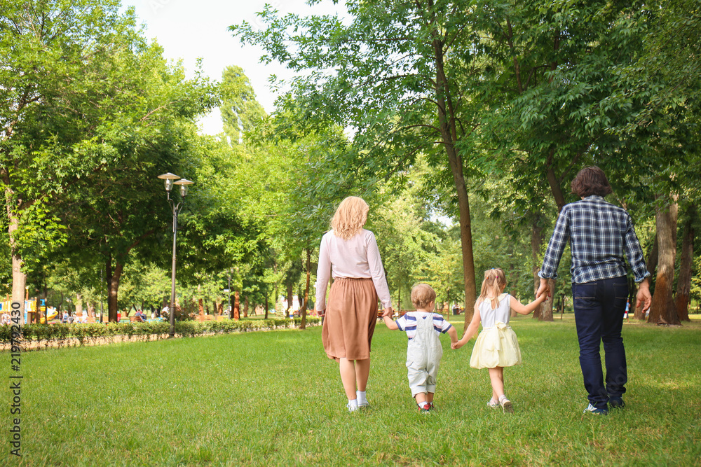 Happy family walking in green park