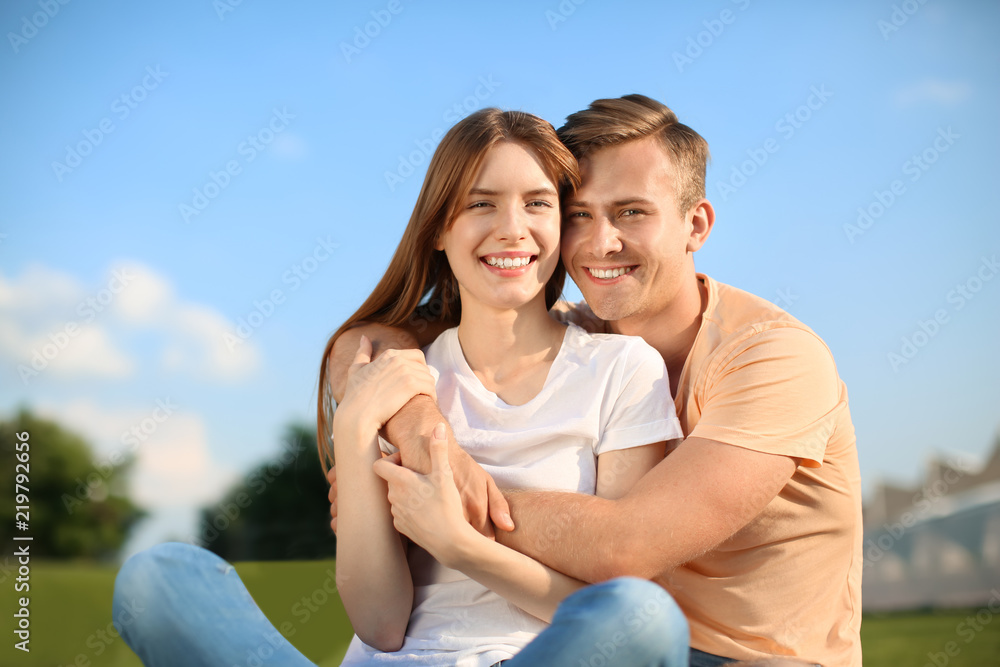 Young couple resting in park on sunny day Young couple resting in park on sunny day