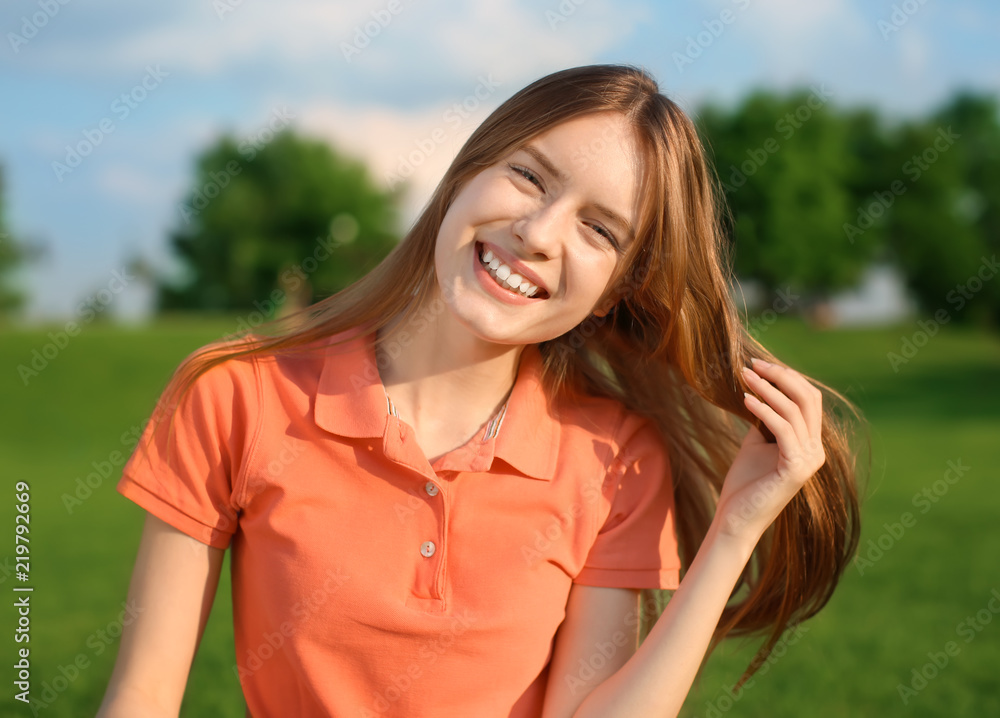 Happy young woman resting in park on sunny day