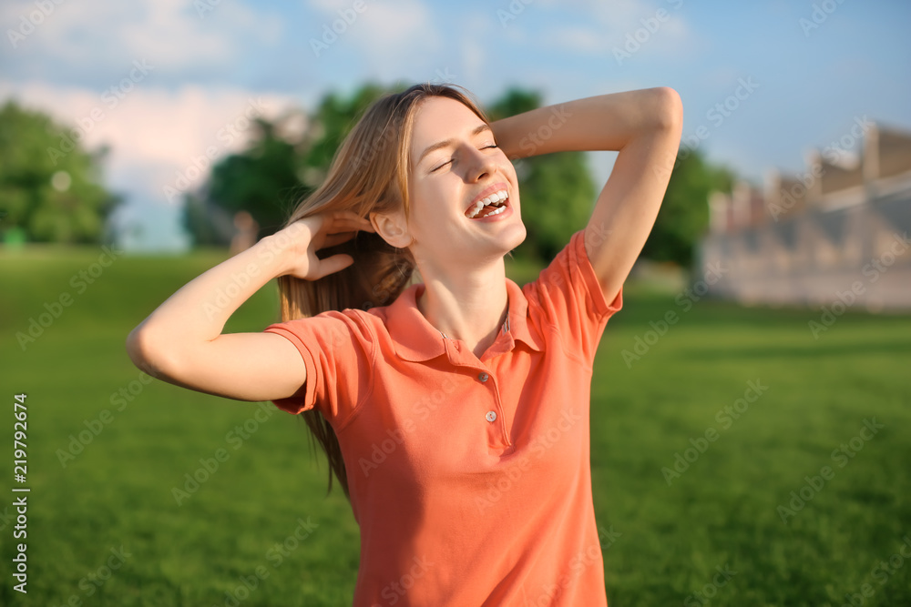 Happy young woman resting in park on sunny day Happy young woman resting in park on sunny day