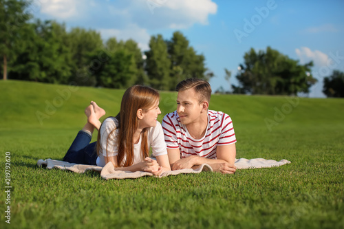Young couple lying on plaid outdoors © Pixel-Shot