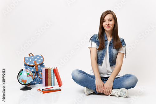 Cuadro en lienzo Full length portrait of young casual smiling woman student in denim clothes sitting near globe backpack, school books isolated on white background