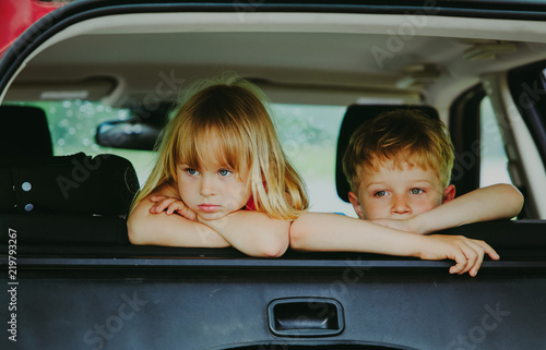 little girl and boy waiting in car bored sad tired