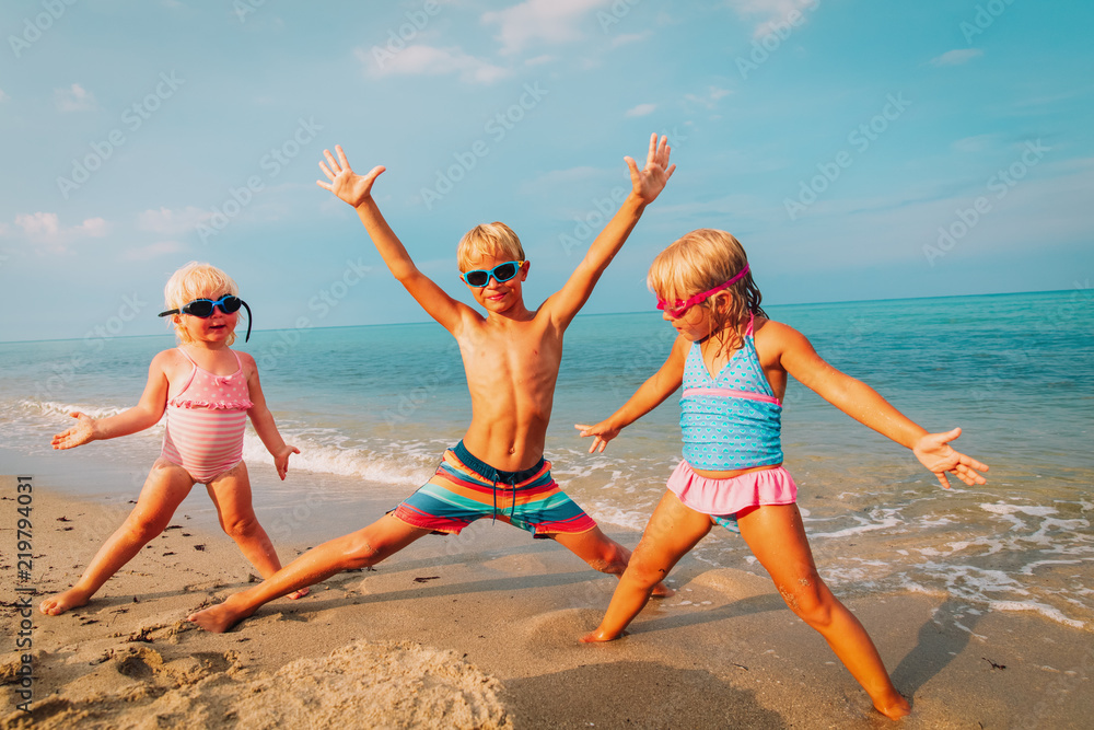 happy kids- little girls and boy-play enjoy beach