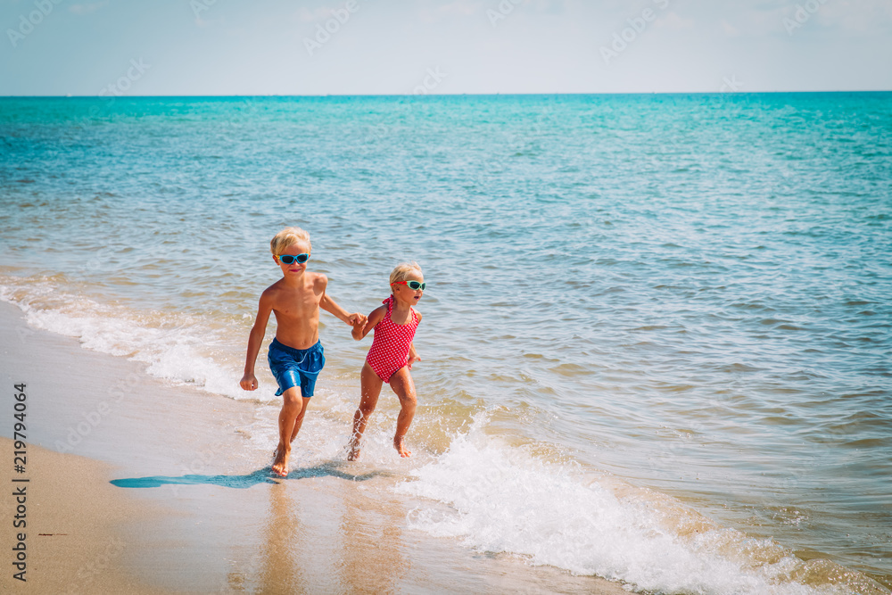 happy kids- boy and girl -running on beach happy kids- boy and girl -running on beach
