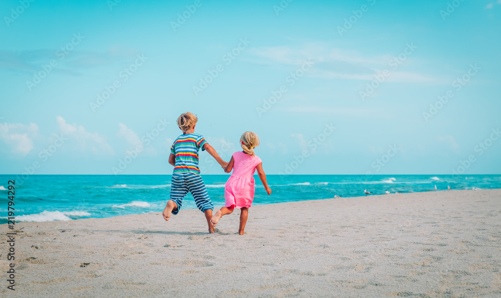 little boy and girl running on beach