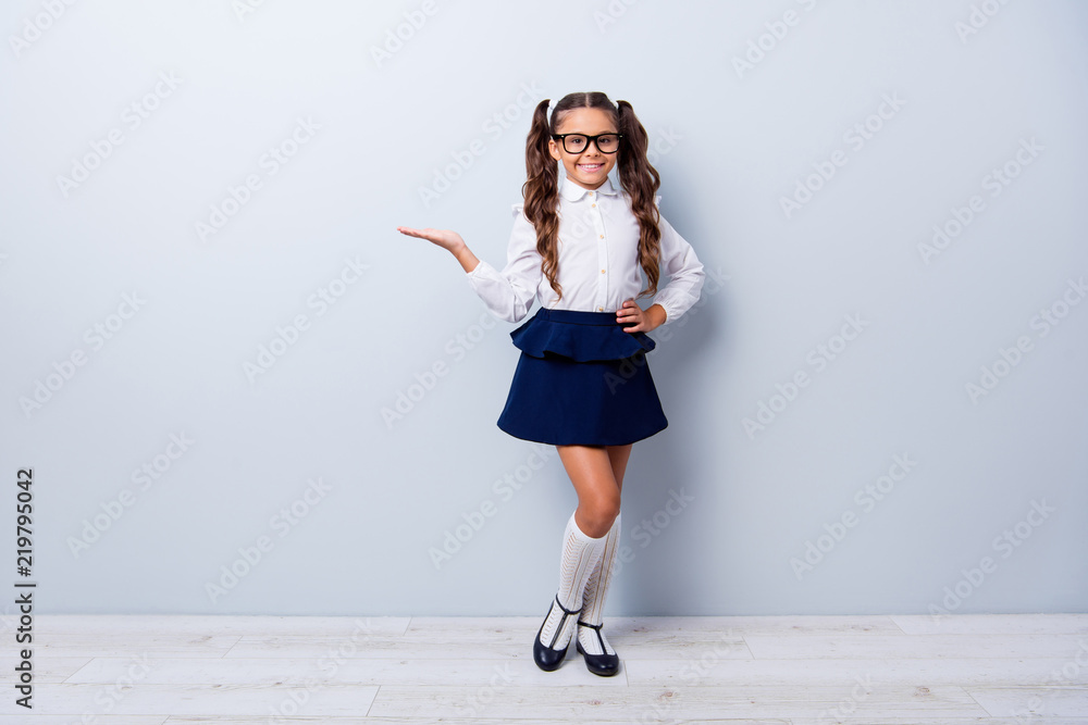 Full body size length of cute cheerful lovely stylish small little girl  with curly ponytails in white formal blouse shirt, short blue skirt, empty  blank copy-space. Isolated over grey background Stock Photo