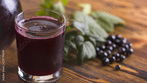 Fresh blackcurrant juice with some fruits on wooden background
