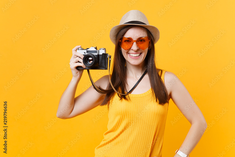 Tourist woman in summer casual clothes, hat take picture on retro vintage photo camera isolated on yellow background. Girl traveling abroad to travel on weekends getaway. Air flight journey concept. Tourist woman in summer casual clothes, hat take picture on retro vintage photo camera isolated on yellow background. Girl traveling abroad to travel on weekends getaway. Air flight journey concept.