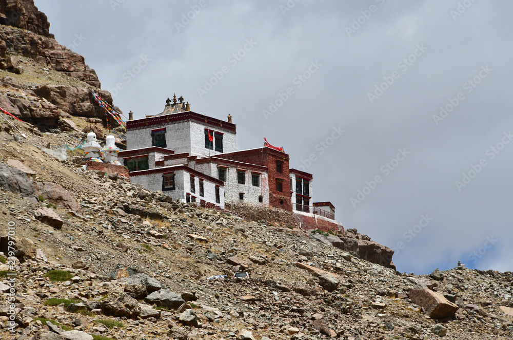 Ancient Buddhist monastery on the mountainside opposite the southern face of mount Kailash (Kailash) in cloudy weather