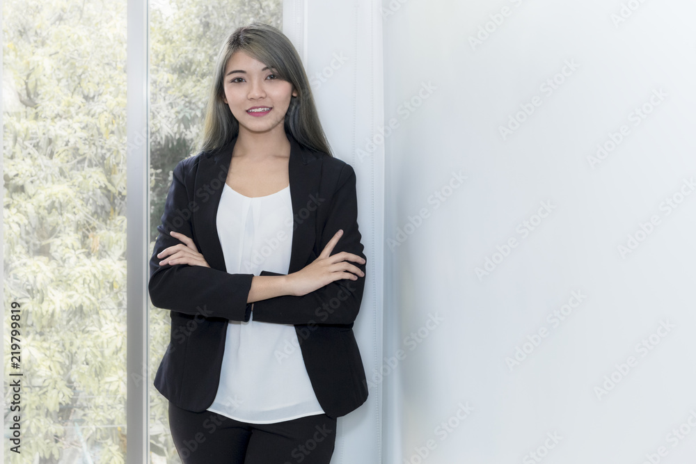 Young businesswoman smiling and thinking about project work at office.Copy space. Young businesswoman smiling and thinking about project work at office.Copy space.
