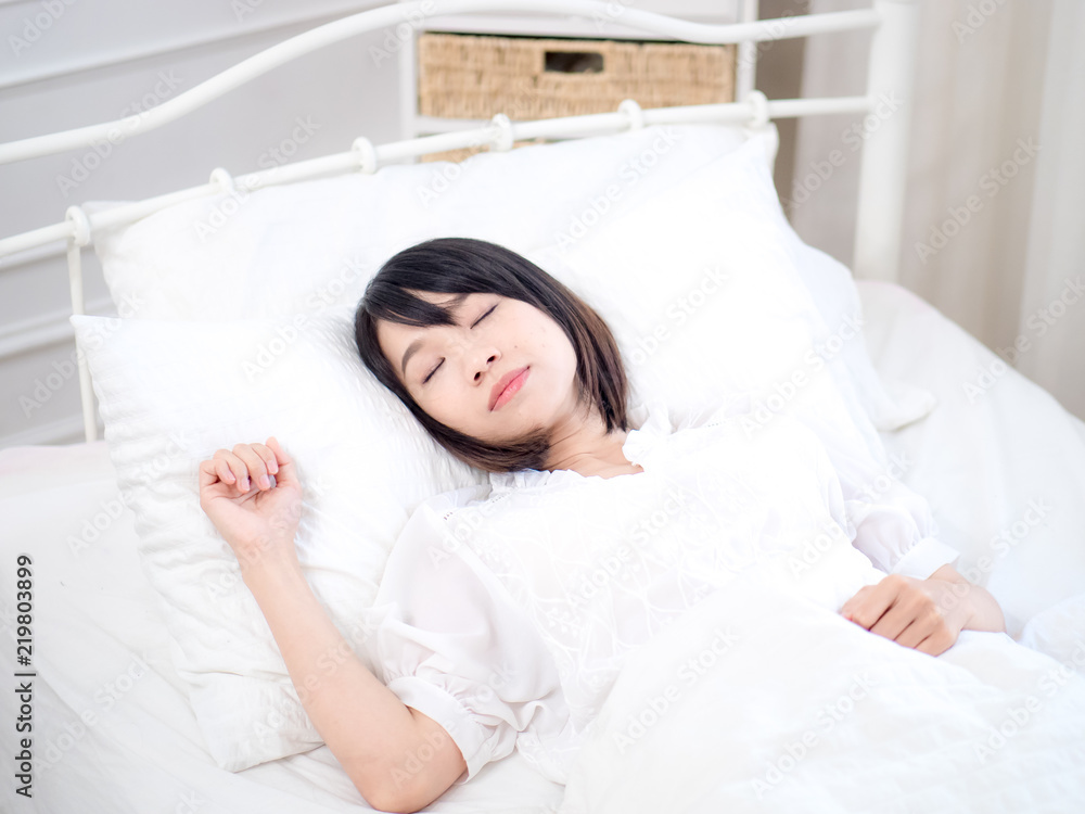 Young woman lying in bed at home in the bedroom Young woman lying in bed at home in the bedroom