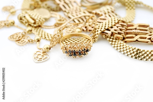 Mixed oriental gold jewelry with necklaces and rings and copy space on white