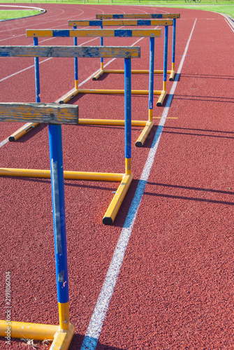 Canvas Print Five obstacles on athletics track in a row