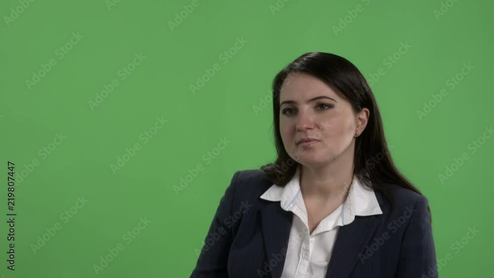 Woman having job interview or other serious conversation against green screen Woman having job interview or other serious conversation against green screen