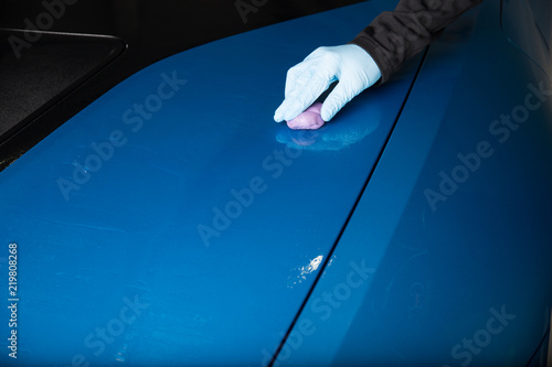 Decontamination with clay bar on blue car