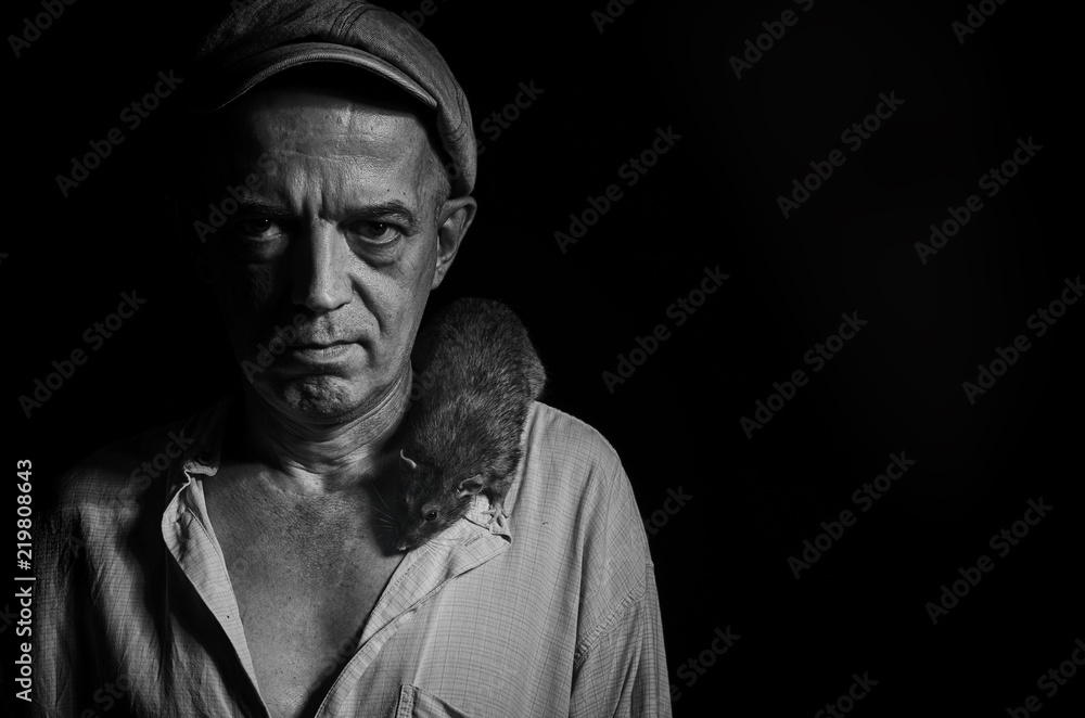 Fototapeta premium Man with a rat on his shoulder in a dark.