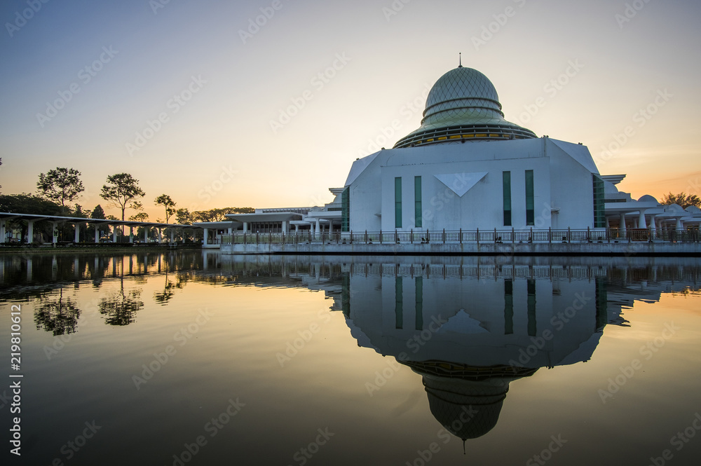 Obraz premium sunrise scenery at Seri Iskandar Public Mosque wth clear reflection. soft focus,blur due to long exposure. visible noise due to high ISO