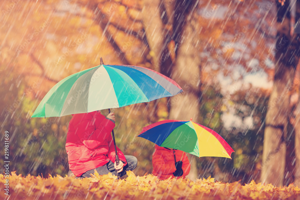 children with umbrellas in beautiful autumnal day