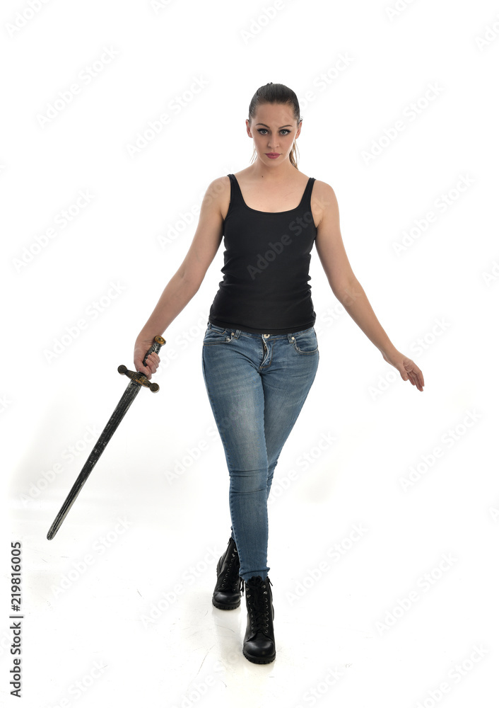 full length portrait of girl wearing brown fantasy costume, holding a sword.  standing pose on white studio background. Stock Photo | Adobe Stock