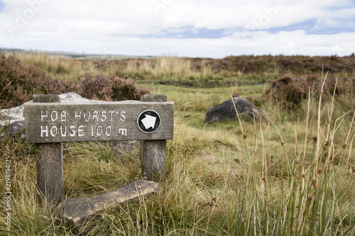 A wooden sign post signifying that is is 100 meters to Hob Hurst`s House in the Peak District