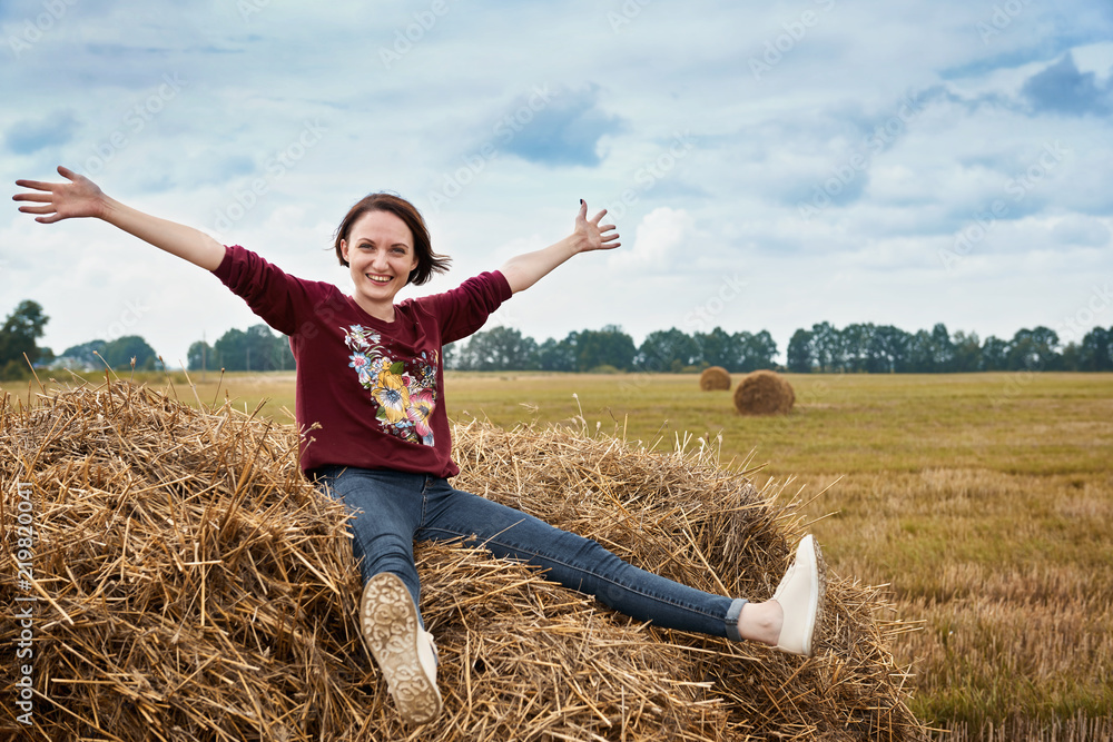 young girl having fun in the field, sitting on a haystack young girl having fun in the field, sitting on a haystack