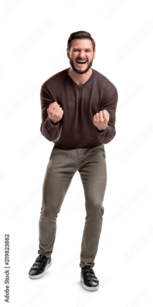 Fototapeta premium An aggressive bearded man in casual clothes shouts at camera, shows his teeth and holds fingers in tight fists.