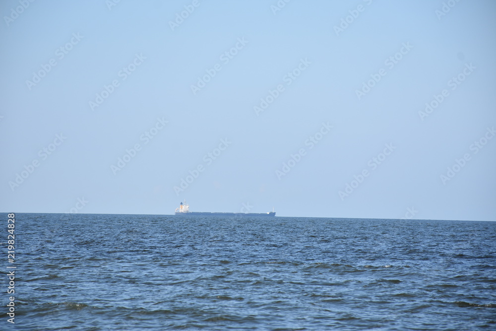 Ocean with cargo ship on horizon