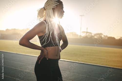 Sprinter walking on running track on a sunny day