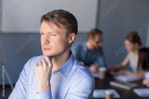 Thoughtful millennial businessman look far in distance, think about business plan and startup project, male employee dream about future success, consider goal achievement. Business vision concept