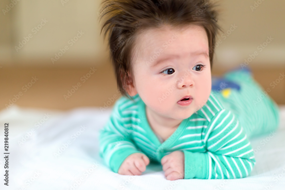 Newborn baby boy laying on the carpet in his pajamas Newborn baby boy laying on the carpet in his pajamas