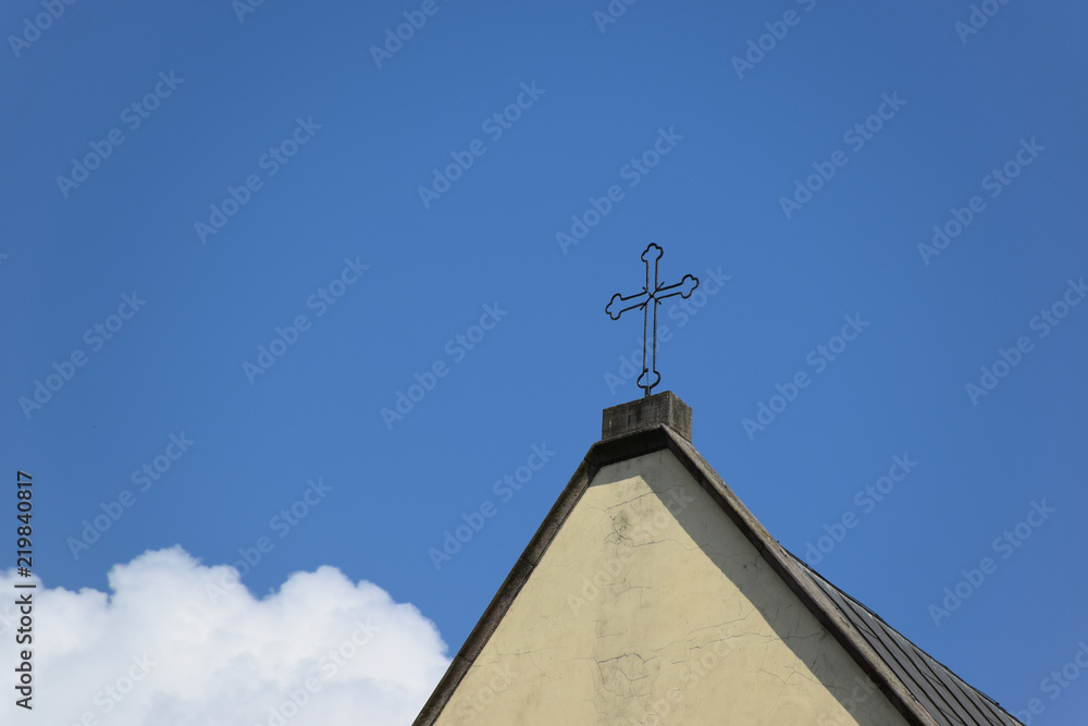 Cross at the orthodox church at blue sky background with white cloud