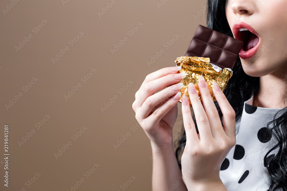 Young woman holding chocolate on a solid background Young woman holding chocolate on a solid background