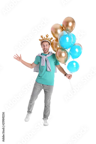 Young man with crown and air balloons on white background © New Africa