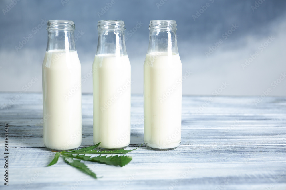 Glass bottles with hemp milk on table Glass bottles with hemp milk on table