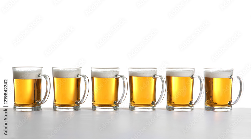 Row of full beer mugs on white background Row of full beer mugs on white background