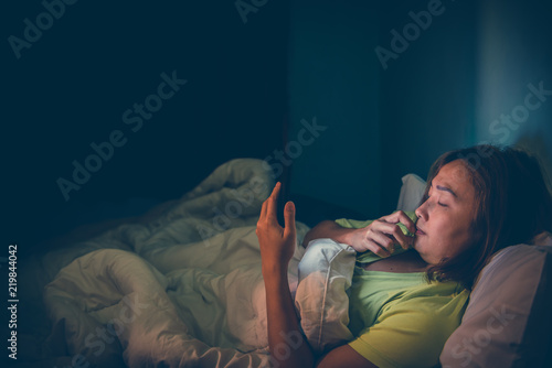 Asian woman play smartphone in the bed at night,Thailand people,Addict social media,Play internet all night