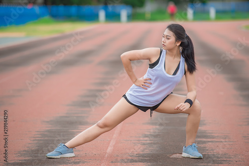 Asian sporty woman stretching body breathing fresh air in the park,Thailand people,Fitness and exercise concept,Jogging in the track