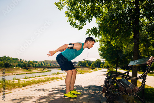 Young male athlete stretching near running track