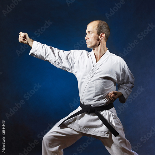 In a karate rack, a man coaches a formal karate exercise