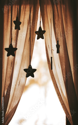 Cozy window curtains with star shape garlands decor.