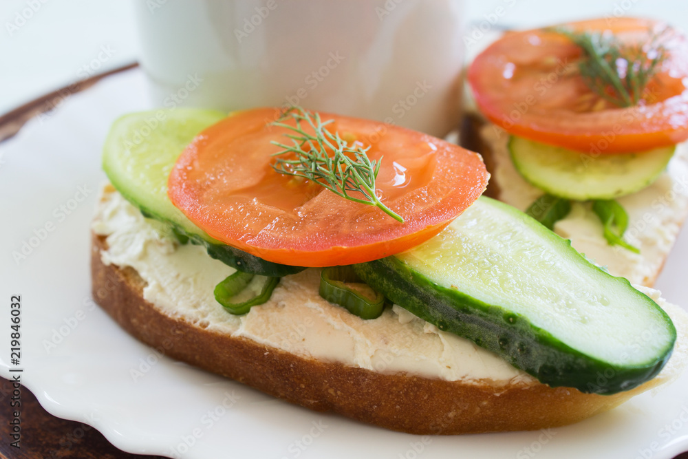 Coffee and sandwiches with cream cheese cucumber and tomato. Breakfast. Traditional breakfast. Copy space. Coffee and sandwiches with cream cheese cucumber and tomato. Breakfast. Traditional breakfast. Copy space.