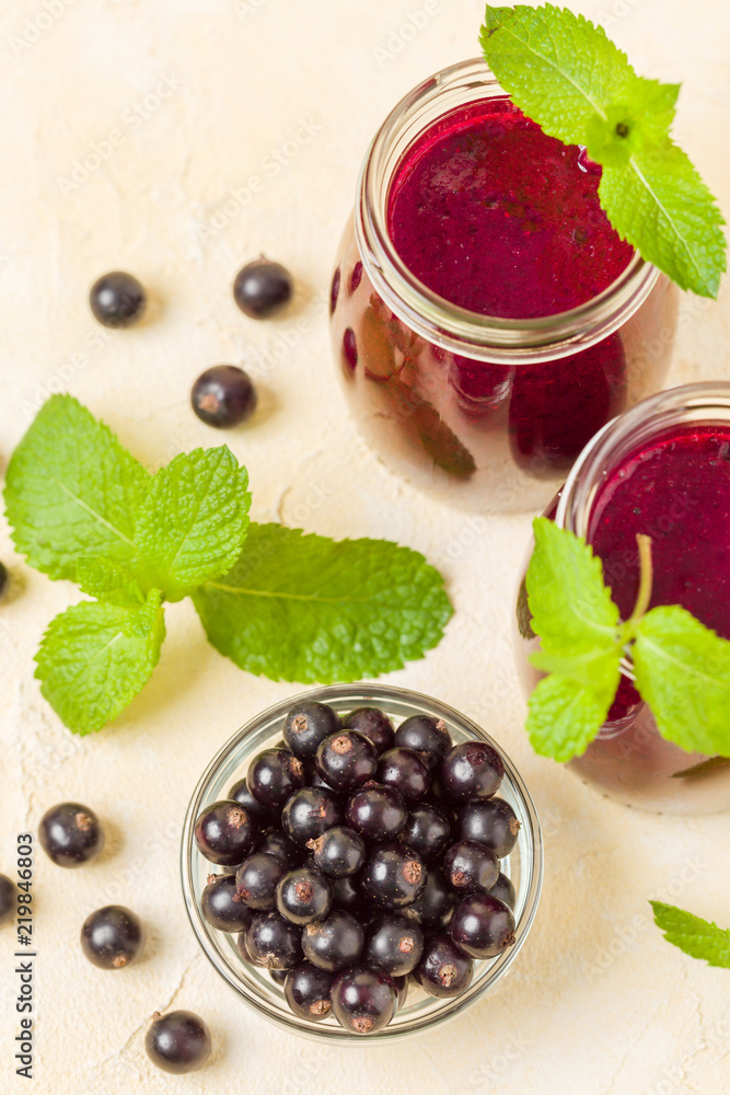 Currant smoothie decorated with fresh green mint leaves and raw ripe berries on yellow pastel background. Currant smoothie decorated with fresh green mint leaves and raw ripe berries on yellow pastel background.