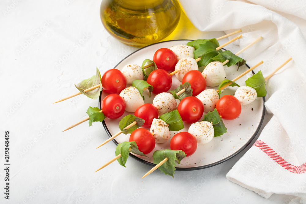 Φωτογραφία Caprese salad - skewer with tomato, mozzarella and basil, italian food and healthy vegetarian diet concept on a light background