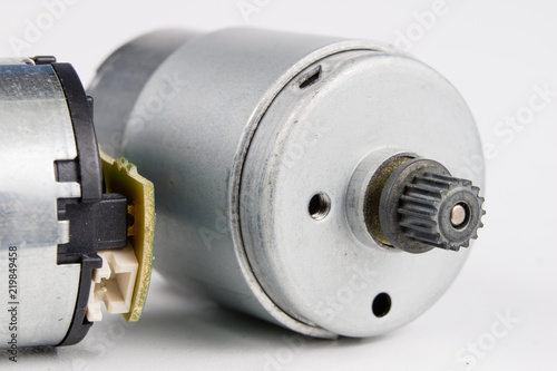Small electric motor on a white workshop table. Electric drive used in small electrical devices.