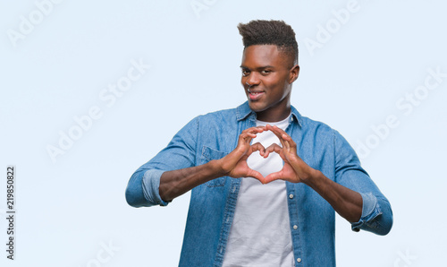 Young african american man over isolated background smiling in love showing heart symbol and shape with hands. Romantic concept.