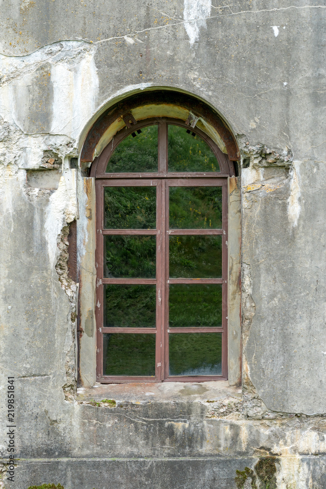 Fototapeta premium old damaged plastered brick wall with window.