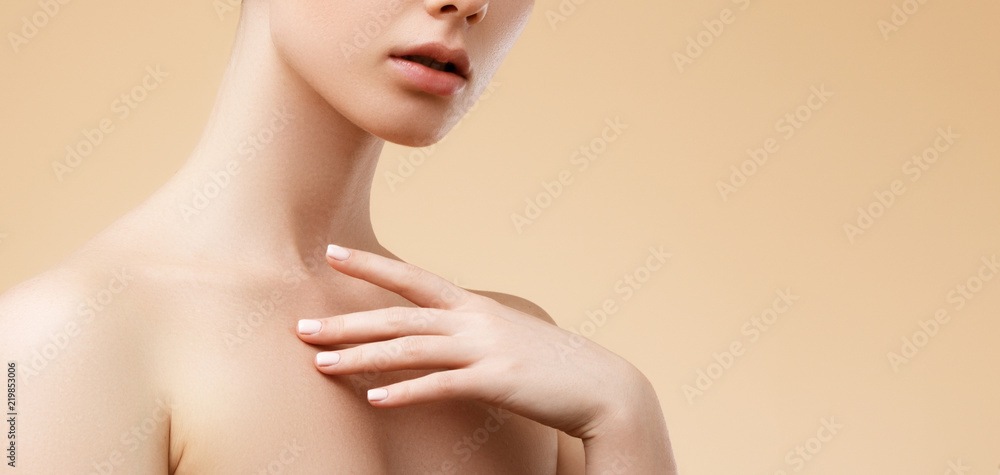 Obraz premium Beauty Spa Woman with perfect skin Portrait. Beautiful blond Spa Girl. Proposing a product. Gestures for advertisement. Beige background